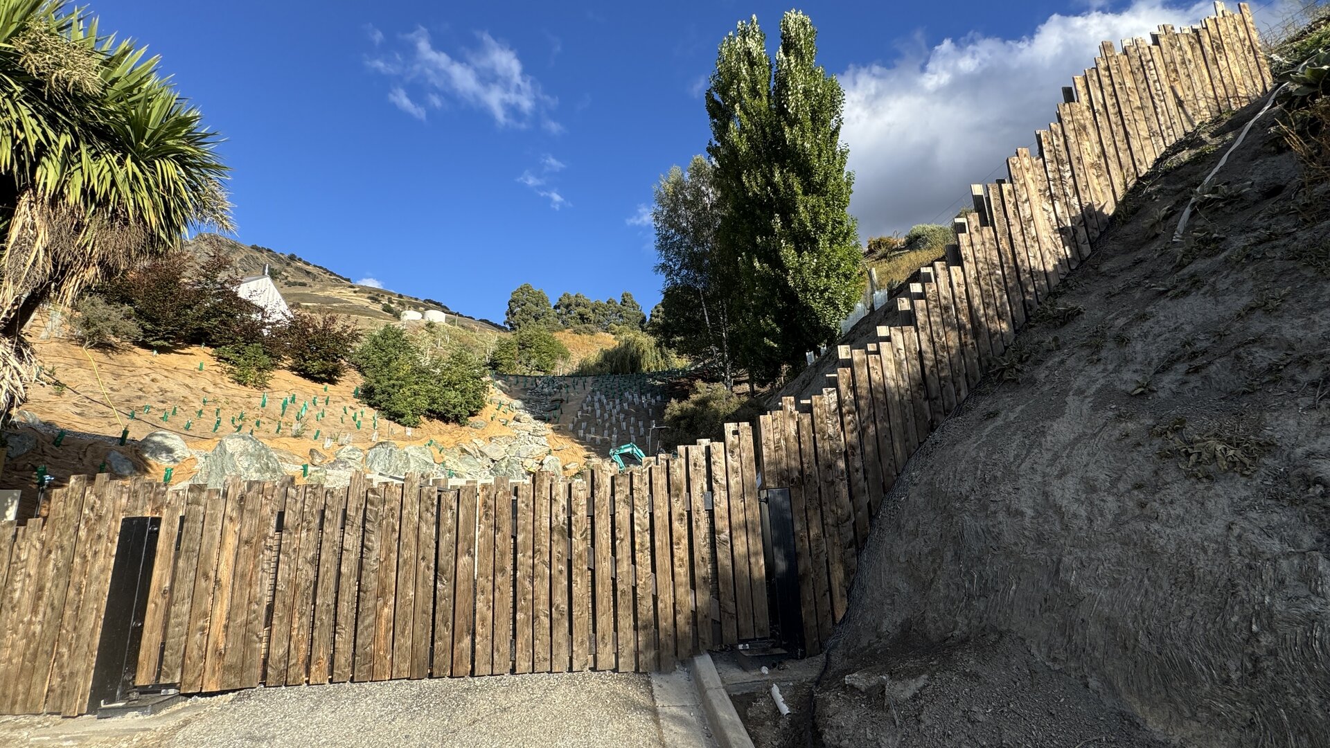 The Threshold completed — aged paling gates in daylight, the property withheld behind