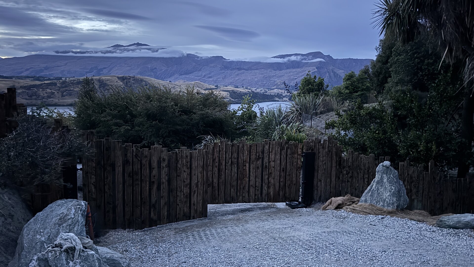 The Threshold — aged timber paling gates at evening